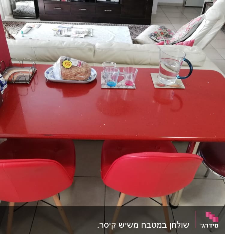 שולחן אדום עם כיסאות אדומים במטבח